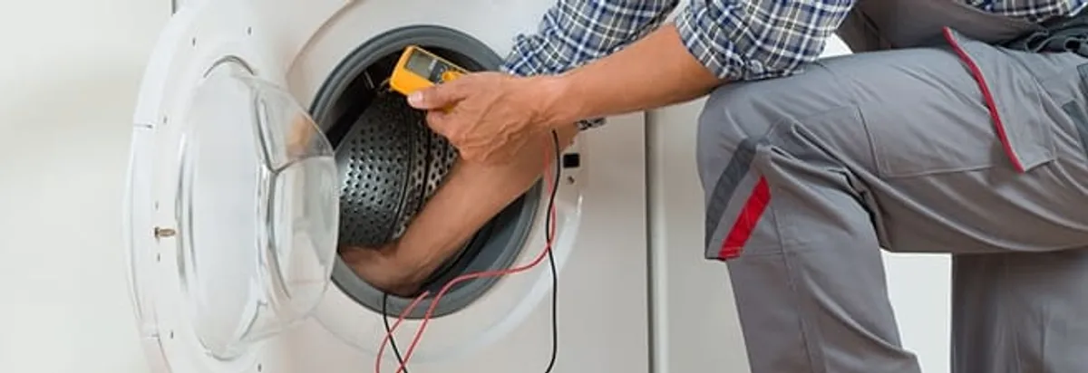 Dryer repair technician inspecting and repairing a clothes dryer in New Orleans, LA
