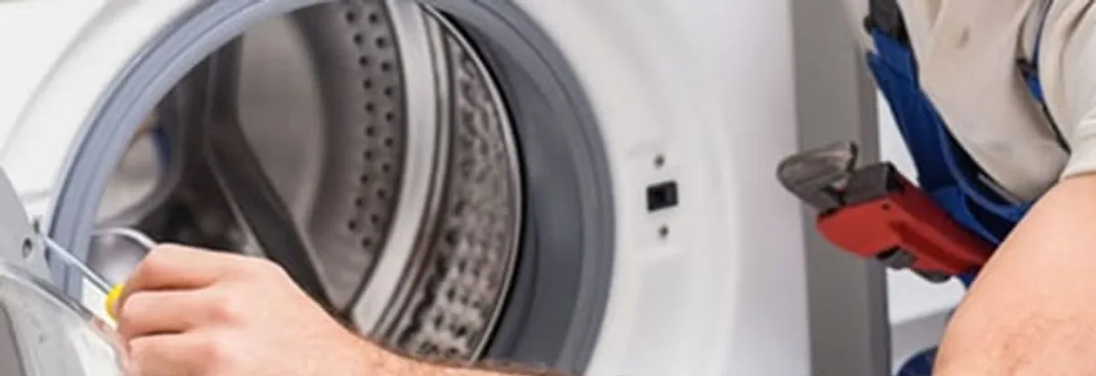 Appliance technician repairing a clothes dryer drum and internal parts in New Orleans, LA