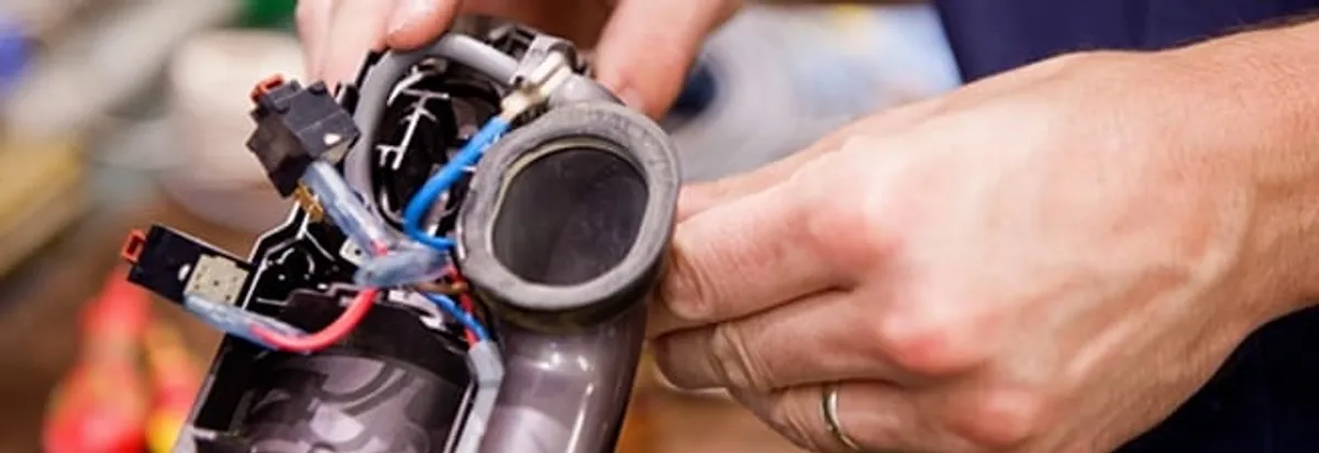 Vacuum repair technician reconnecting wiring and components in New Orleans, LA